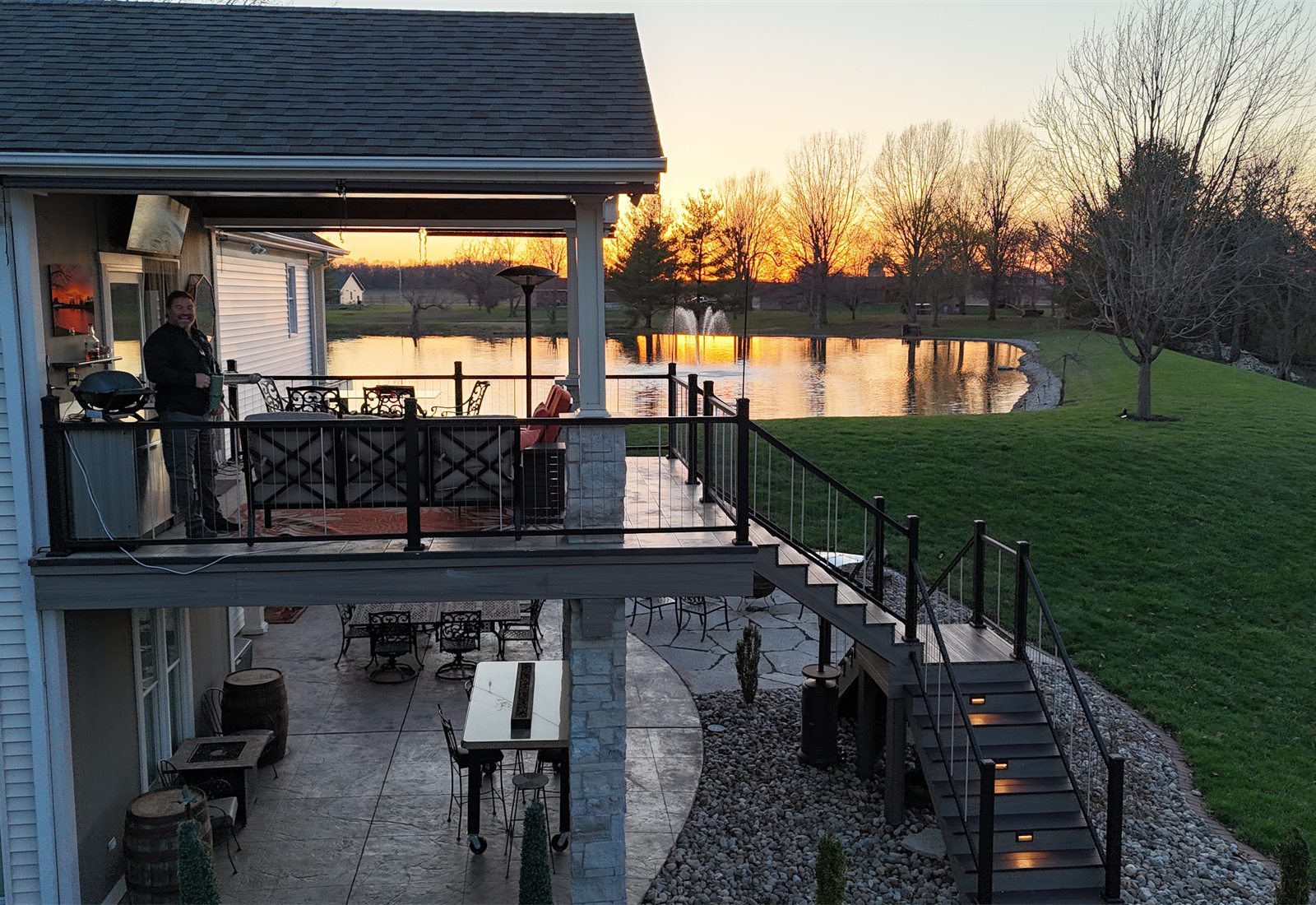 Finished exterior deck and patio overlooking a lake