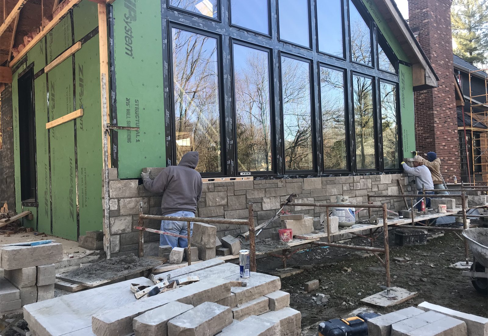 Exterior masonry and window installation in progress